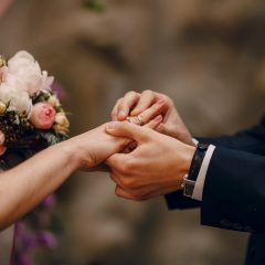 Bruidegom schuift een trouwring om de vinger van de bruid